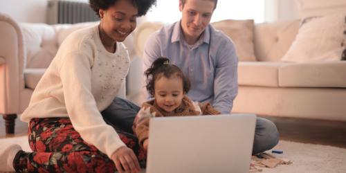 Mutter, Vater, Kind vor Laptop