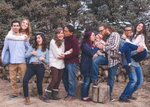 Familie mit steht vor einem Wald. Zu sehen sind alle Generationen von Jung bis alt.