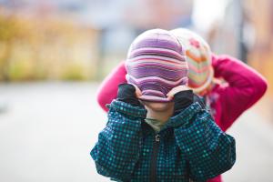 Kinder mit heruntergezogenen Mützen auf dem Kopf
