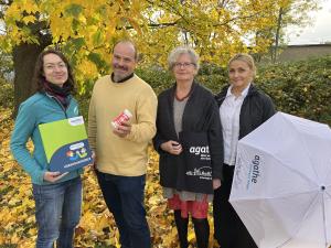 Team Agathe Frau Rauch, Herr Dölz, Frau Osse, Frau Klose-Leitel mit Vorsorgeordner und Regenschirm im Herbstlaub