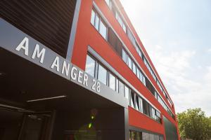 Eingangsbereich des Verwaltungsgebäudes Am Anger 28 mit roter Fassade