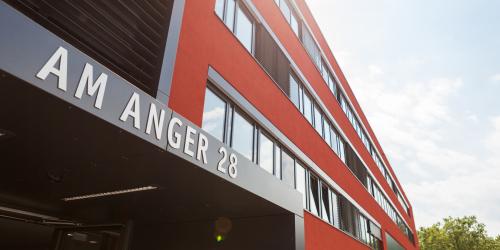 Eingangsbereich des Verwaltungsgebäudes Am Anger 28 mit roter Fassade