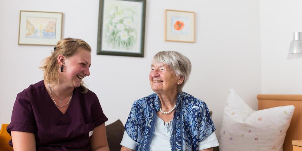 Ältere Dame schaut zu jüngerer Frau