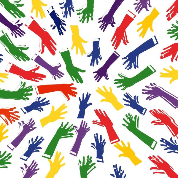 Mehrfarbige Hände zeigen in die Mitte